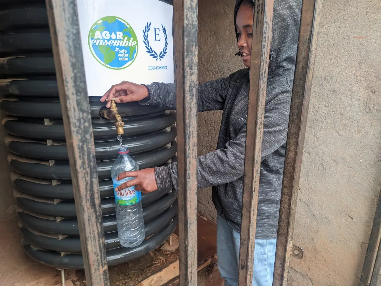 Personne remplissant une bouteille à partir du robinet d'un réservoir d'eau.